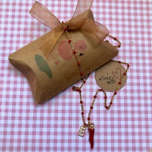 Croissant vermelho e colar de letras com strass