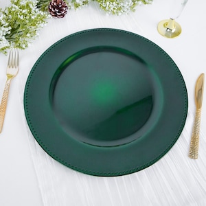 May include: A dark green charger plate with a beaded edge. The plate is made of plastic and has a glossy finish.