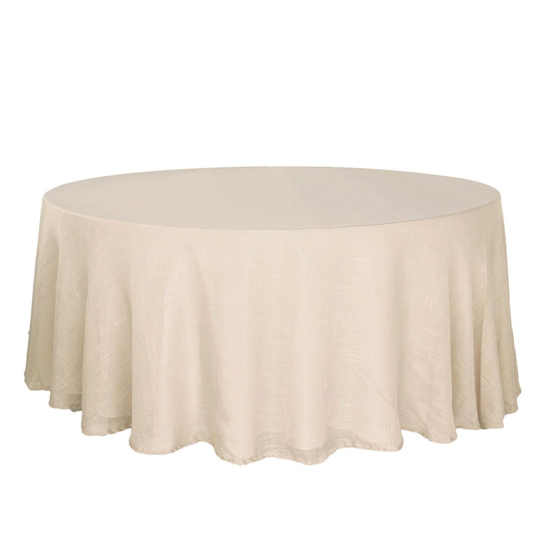 May include: A round, beige linen tablecloth. The tablecloth is smooth and has a subtle sheen.