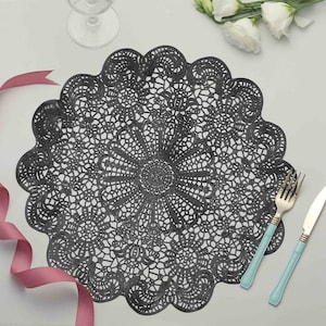 Puede incluir: Salvamanteles de encaje negro con un delicado dise&ntilde;o floral. El salvamanteles es redondo y tiene un borde festoneado.
