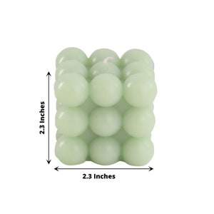May include: A light green cube-shaped candle with a textured surface. The candle is 2.3 inches wide and 2.3 inches tall.