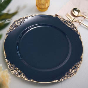 May include: A navy blue charger plate with a gold ornate rim. The plate is round and has a smooth surface.