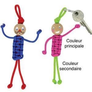 Puede incluir: Dos figuras de llavero de paracord de colores con caras sonrientes. La figura de la izquierda es azul y roja, y la figura de la derecha es rosa y verde. El texto "Couleur principale" y "Couleur secondaire" es visible en la imagen.