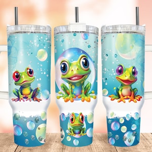 May include: Three stainless steel tumblers with a blue background and a frog design. The frogs are green with red, yellow, and blue accents. The tumblers have white lids and straws.