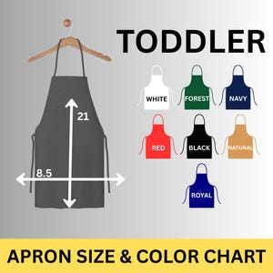 May include: A grey toddler apron, 53 cm long and 21.6 cm wide, hangs on a wooden hanger. The image includes a colour chart with aprons in white, forest green, navy, red, black, natural, and royal blue. Text reads "TODDLER" and "APRON SIZE & COLOUR CHART."