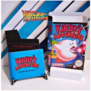 May include: A vintage video game box and instruction manual for "Kirby's Adventure" are shown. The box has a colourful illustration of Kirby. The manual is blue with red text. The background features a "Hack to the Future" design.