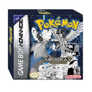 May include: A black and white Game Boy Advance game cartridge case for Pokemon Ash Gray Version. The case features a blue background with a white Pokemon logo and the text "Ash Gray Version". The case also features images of Pokemon characters, including Charizard, Pikachu, and Squirtle.