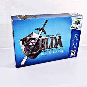 May include: A blue Nintendo 64 game box featuring a gold and black image of Link's sword and shield. The game title is "The Legend of Zelda: Ocarina of Time - Demon's Quest".