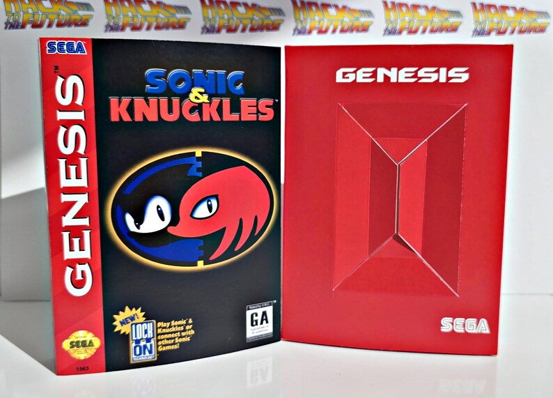 K&ouml;nnte beinhalten: Eine SEGA Genesis Videospielbox f&uuml;r Sonic & Knuckles. Die Box ist schwarz mit dem Spieltitel in Blau und Rot. Das Cover zeigt Sonic und Knuckles. Daneben eine rote Genesis-Box.