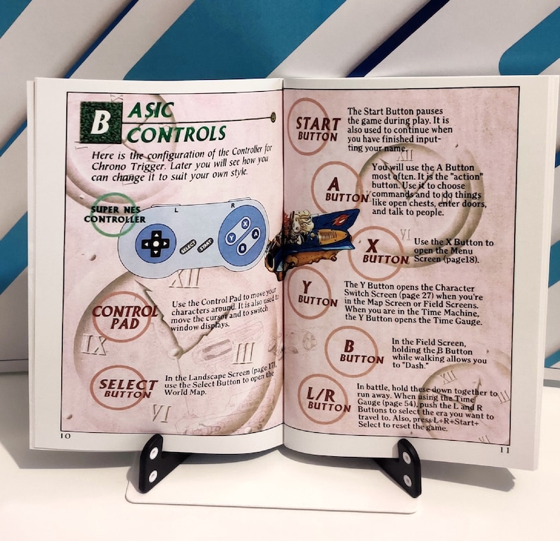 Puede incluir: Libro abierto con diagrama de mando de juego. La p&aacute;gina izquierda muestra un mando Super NES y el texto "Basic Controls". La p&aacute;gina derecha detalla las funciones de los botones como "Start", "A", "X", "Y", "B" y "L/R".