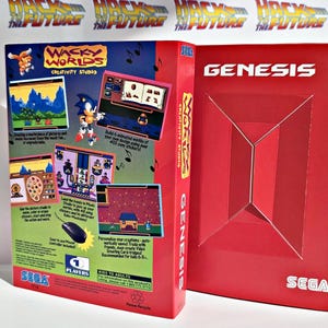 K&ouml;nnte beinhalten: Zwei SEGA Genesis-Spielboxen. Die linke Box ist f&uuml;r "Wacky Worlds Creativity Studio" mit Sonic the Hedgehog und Spiel-Screenshots. Die rechte Box ist rot mit dem Wort "GENESIS" und einem geometrischen Design. Der Hintergrund hat den Text "Back to the Future".