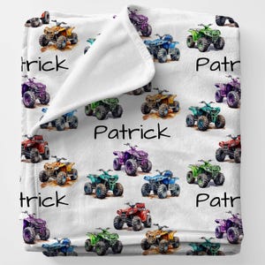 May include: A white fleece blanket with a colorful repeating pattern of ATVs. The blanket has the name "Patrick" written on it twice.