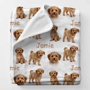 May include: A white ceramic mug with a black handle and the text "But First, Coffee" in a bold, black font. The mug is set against a blurred background, suggesting a cozy setting.