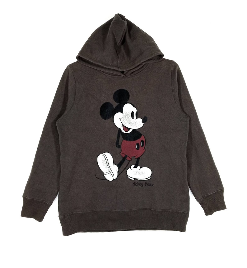 May include: A brown hooded sweatshirt with a vintage Mickey Mouse graphic on the front. The graphic is in black, white, and red. The text "Mickey Mouse" is printed below the graphic.