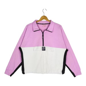 May include: A pink and white half-zip sweatshirt with black trim and a DKNY logo on the front.