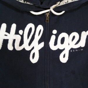 May include: A navy blue zippered hoodie with a white "Hilfiger Denim" logo.