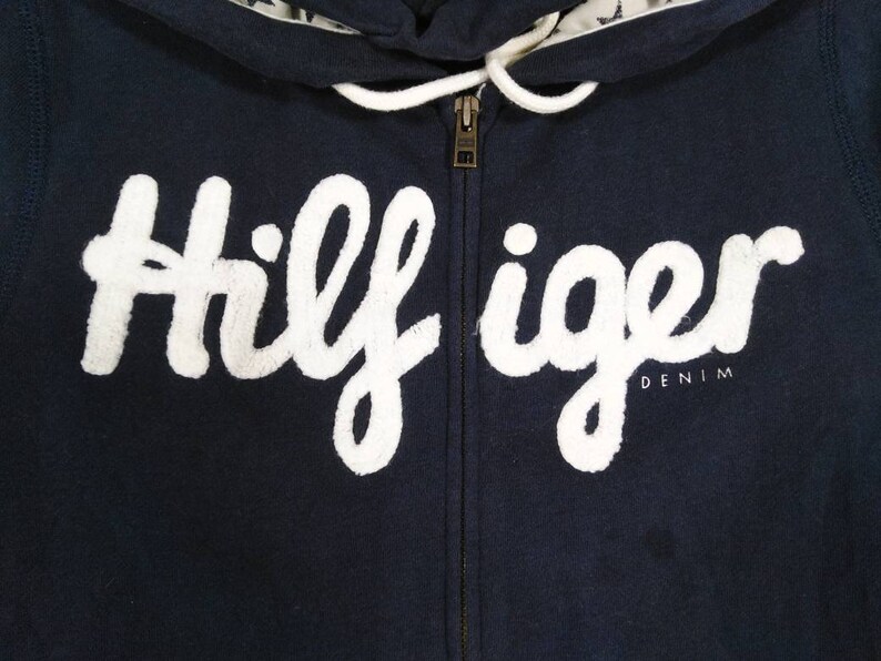 May include: A navy blue zippered hoodie with a white "Hilfiger Denim" logo.