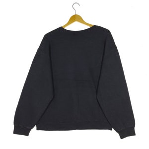 May include: A black sweatshirt with a crew neck and long sleeves.