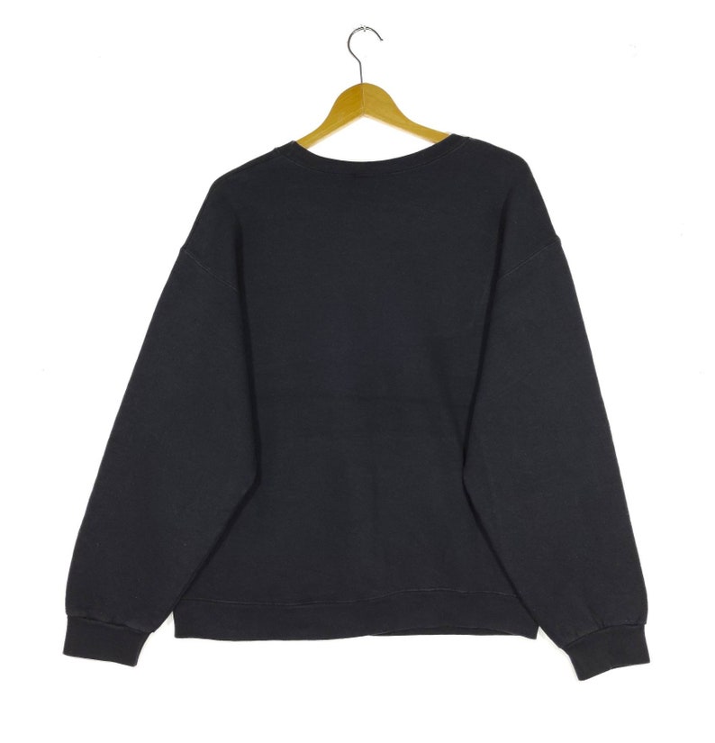 May include: A black sweatshirt with a crew neck and long sleeves.