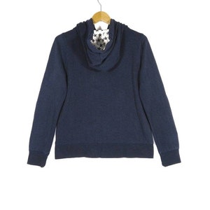 May include: A navy blue zip-up hoodie with a star-patterned hood lining.