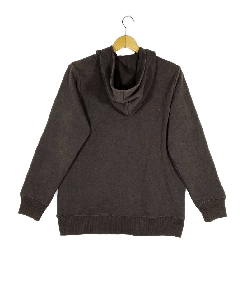 May include: A dark brown hooded sweatshirt with a drawstring hood. The sweatshirt has long sleeves and a ribbed hem and cuffs.