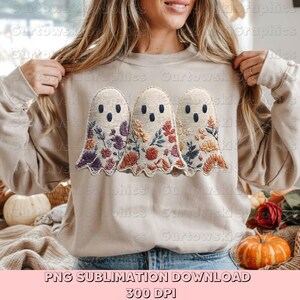 May include: A beige sweatshirt featuring three embroidered ghost designs with floral patterns in purple, orange, and yellow. The text "PNG SUBLIMATION DOWNLOAD 300 DPI" is at the bottom.