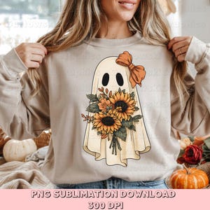 May include: A beige sweatshirt featuring a ghost design with a bow and a bouquet of sunflowers. The ghost has two black oval eyes. The bouquet includes sunflowers and other orange and yellow flowers. The text "PNG SUBLIMATION DOWNLOAD 300 DPI" is at the bottom.