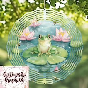 May include: A green frog sits on a lily pad in a pond with pink water lilies and bees. The image is a metal wind spinner with a circular design.