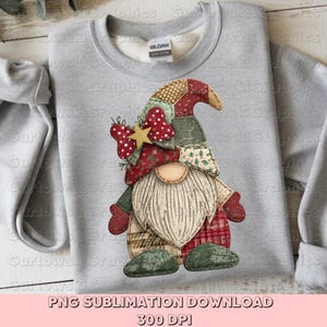 Könnte beinhalten: Ein hellgraues Sweatshirt mit einem farbenfrohen Zwergen-Design. Der Zwerg hat einen langen weißen Bart, einen Patchwork-Hut und rote Fäustlinge. Das Design beinhaltet eine rote Schleife mit einem goldenen Stern. Der Text "PNG SUBLIMATION DOWNLOAD 300 DPI" steht unten.