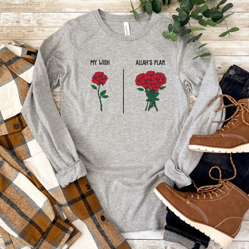 May include: Gray long-sleeve t-shirt with the text "My Wish" and a single red rose on the left side and "Allah's Plan" with a bouquet of red roses on the right side.