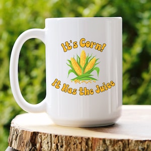 May include: White ceramic coffee mug with a yellow and green corn design and the text "It's Corn! It Has the Juice".