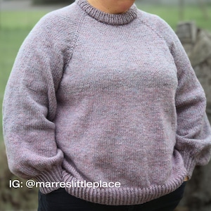 May include: A soft, light purple sweater with a crew neck and long sleeves. The sweater has a subtle speckled pattern and a ribbed hem and cuffs.