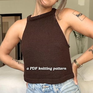 May include: A brown knitted halter top with a high neckline. The top is a solid color and appears to be handmade. The text "a PDF knitting pattern" is displayed on the front of the top.