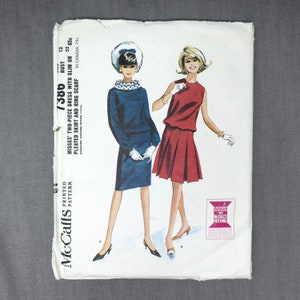 以下が含まれることがあります： ヴィンテージのMcCall's縫製パターン。プリーツスカートとリングスカーフ付きのツーピースドレス。パターン番号は7386、バストサイズは12。パターンは白地に青と赤のイラストで、ドレスを着た女性2人が描かれています。