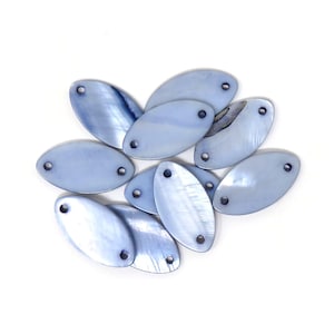May include: A group of ten light blue oval-shaped shell beads with two holes each. The beads are arranged in a loose pile on a white background.