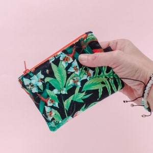Monedero selva sobre fondo negro de tela con cremallera. Billetera con cremallera. Pack bolsa-tarjetero y llavero. Key fob selva.