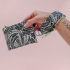 Monedero con cremallera blanco y negro. Llavero de correa para muñeca. Portamonedas de tela estampado hojas botánicas en blanco y negro.