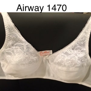 May include: White bra with lace detailing on the cups and straps. The bra has a bow in the center and a tag that reads "Constraint". The text "Airway 1470" is above the bra.