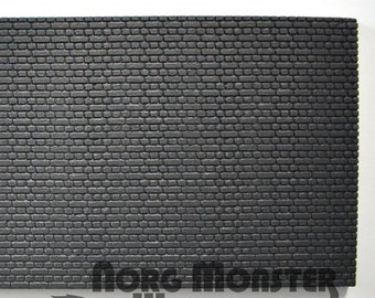 May include: Black textured brick wall backdrop for model railroading or miniature scenes.  The backdrop is made of a lightweight material and is easy to cut and shape.  It measures approximately 12 inches by 36 inches.  The backdrop is made by the company "More Monster Workshop".