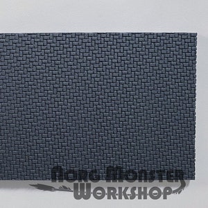 May include: A sheet of dark grey textured foam with a woven pattern. The foam is used for model making and crafting.
