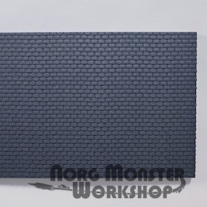 May include: A sheet of dark gray textured foam, resembling a brick wall, with the text "Norg Monster Workshop" printed in white at the bottom right corner.
