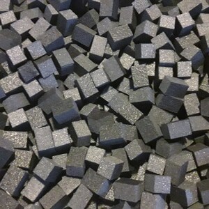 May include: A close-up image of a pile of small, gray, foam cubes. The cubes are all roughly the same size and shape, and they are arranged in a random pattern.