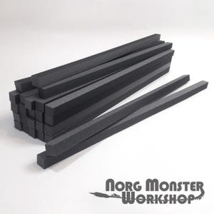 Könnte beinhalten: Ein Stapel schwarzer Schaumstoffstäbe, etwa 30 cm lang und 1,2 cm breit. Die Stäbe sind in einem ordentlichen Stapel angeordnet, wobei die Enden der Stäbe ausgerichtet sind. Die Stäbe bestehen aus einem weichen, flexiblen Schaumstoffmaterial.