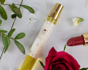 May include: A small glass bottle of rose absolute perfume with a gold cap and a white label that says "LOVE organic fragrances" and "Eau De Parfum - 10 ml - Rose Absolute".