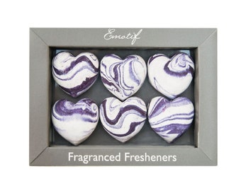 May include: Six purple and white marbled heart-shaped fragranced fresheners in a gray box with the text "Emotif" and "Fragranced Fresheners".