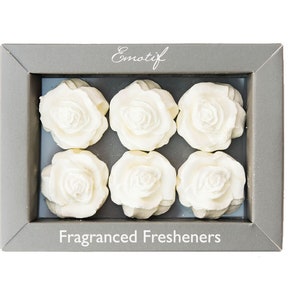 May include: A box of six white rose-shaped fragranced fresheners in a grey box with the word "Emotif" and "Fragranced Fresheners" printed on the front.