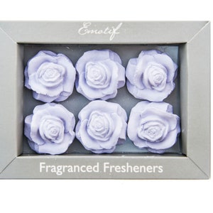 May include: Six lavender-coloured rose-shaped air fresheners in a grey box with the text "Emotif Fragranced Fresheners".