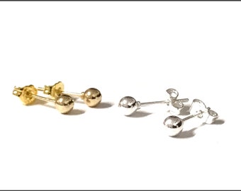 May include: Two pairs of stud earrings. One pair is gold-coloured, and the other is silver-coloured. Each earring features a small, round ball at the end of a post with a butterfly backing. The earrings are displayed on a white background.