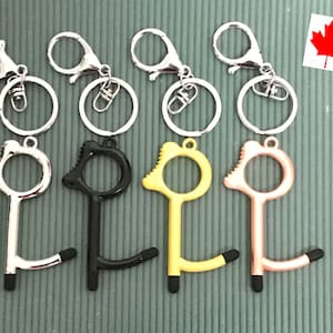 May include: A selection of keyrings in silver, black, yellow, and rose gold. Each keyring has a touch tool with a stylus tip and a lobster clasp for attachment. The keyrings are designed for contactless use.