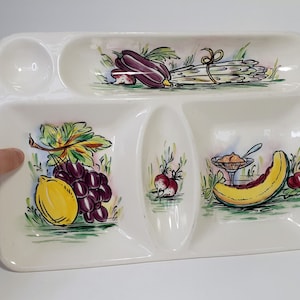 May include: White ceramic divided serving tray with a painted design of various fruits and vegetables. The tray has four sections, one large and three smaller.